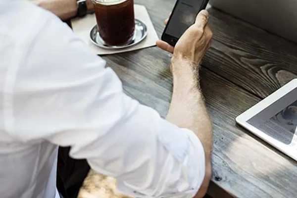 Person som jobber digitalt med mobil og laptop